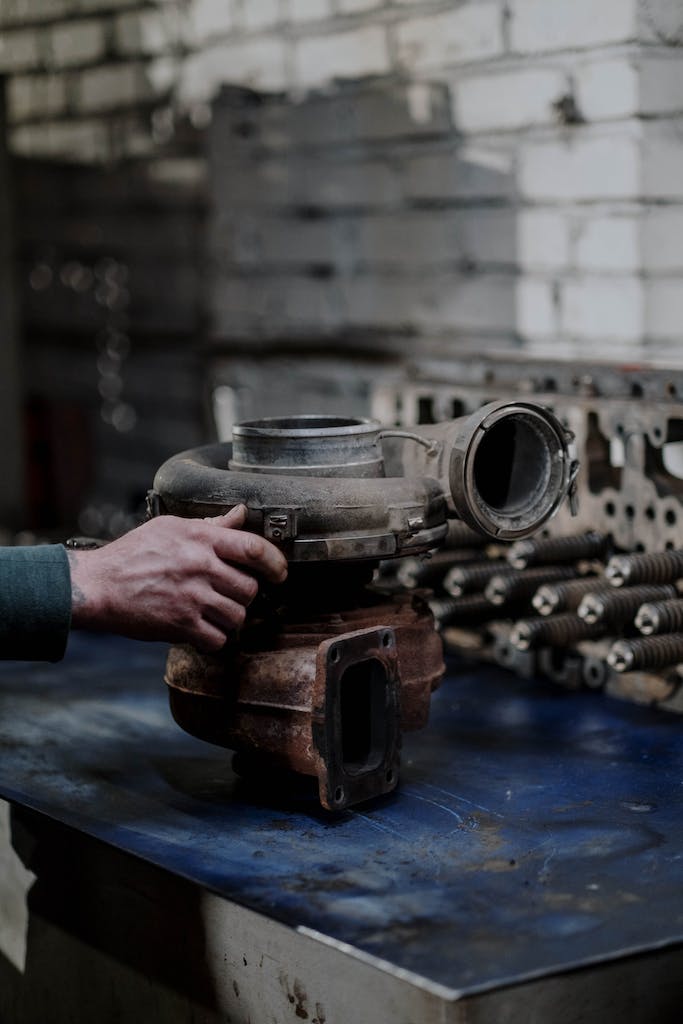Person Holding a Rusty Engine Turbo